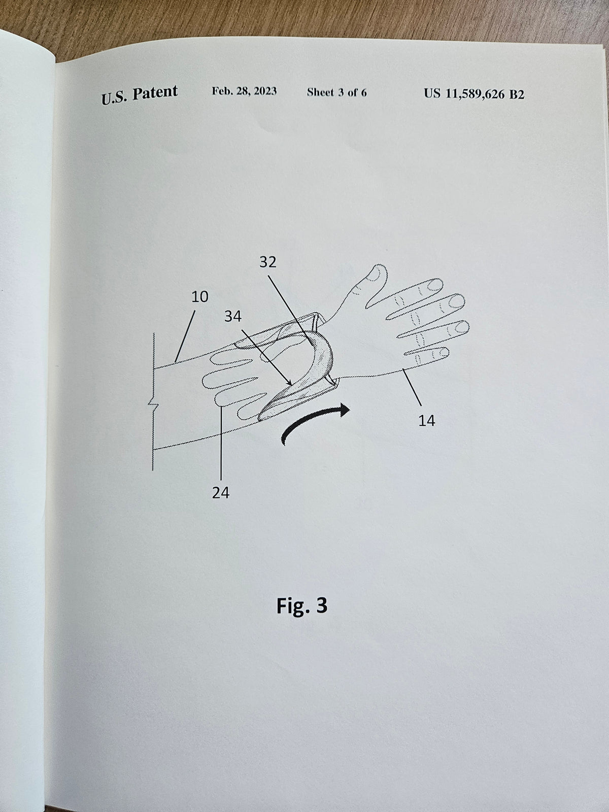 Figure 3 of U.S. Patent 11,589,626 B2 showing the integrated glove unfolding from the sleeve toward the hand