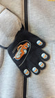 Kids’ jacket with attached black gloves featuring embroidered orange and blue cartoon design on the hand and fingertips